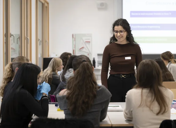 Modulverantwortliche am TecDay steht vor der Klasse. Vor ihr sind zwei Reihen mit Schüler:innen.