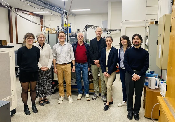 Groupe de personnes posant dans un laboratoire scientifique moderne.