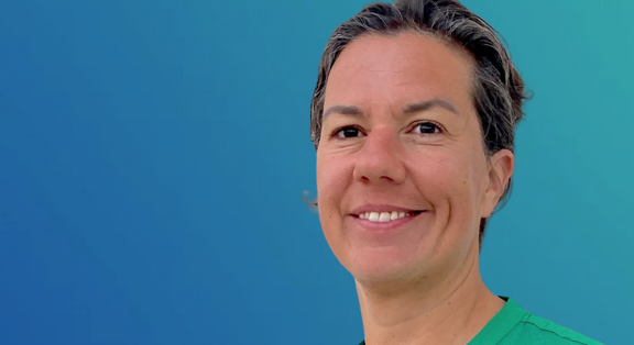 Alessa Hool in grüner Kleidung vor blauem Hintergrund