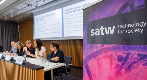 Bannière de la SATW à côté d'une table ronde dans la salle de conférence.