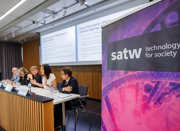 SATW banner next to a panel discussion in the conference room.