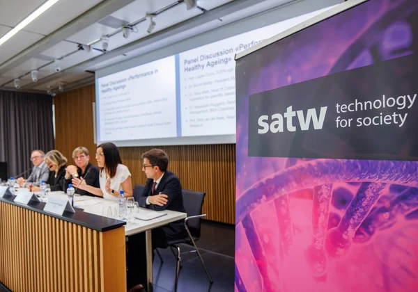 SATW Banner neben einer Podiumsdiskussion im Konferenzraum.