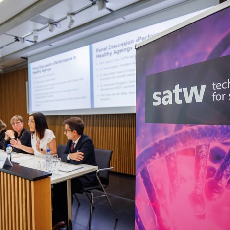 SATW banner next to a panel discussion in the conference room.