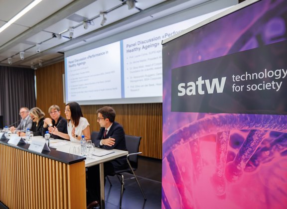 SATW banner next to a panel discussion in the conference room.