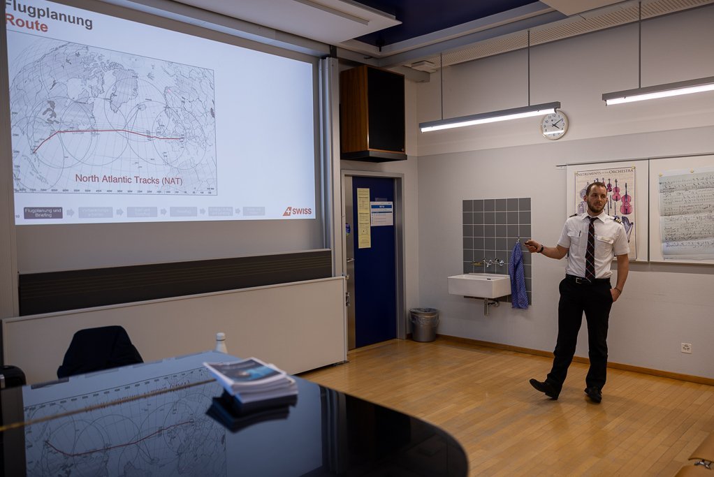 Pilot presents flight planning in front of a map.