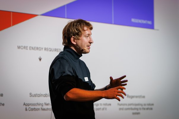 Samuel Huber gives a lecture in front of a projection screen with diagrams