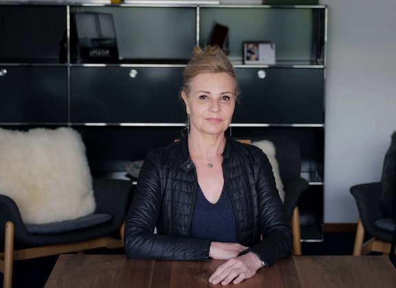 Woman in black jacket sitting at a table
