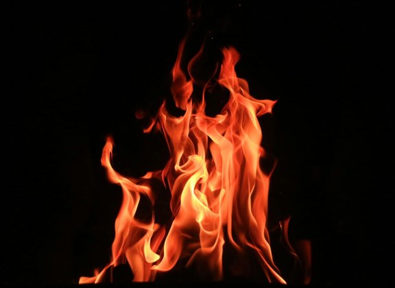 Flames dance in front of a black background
