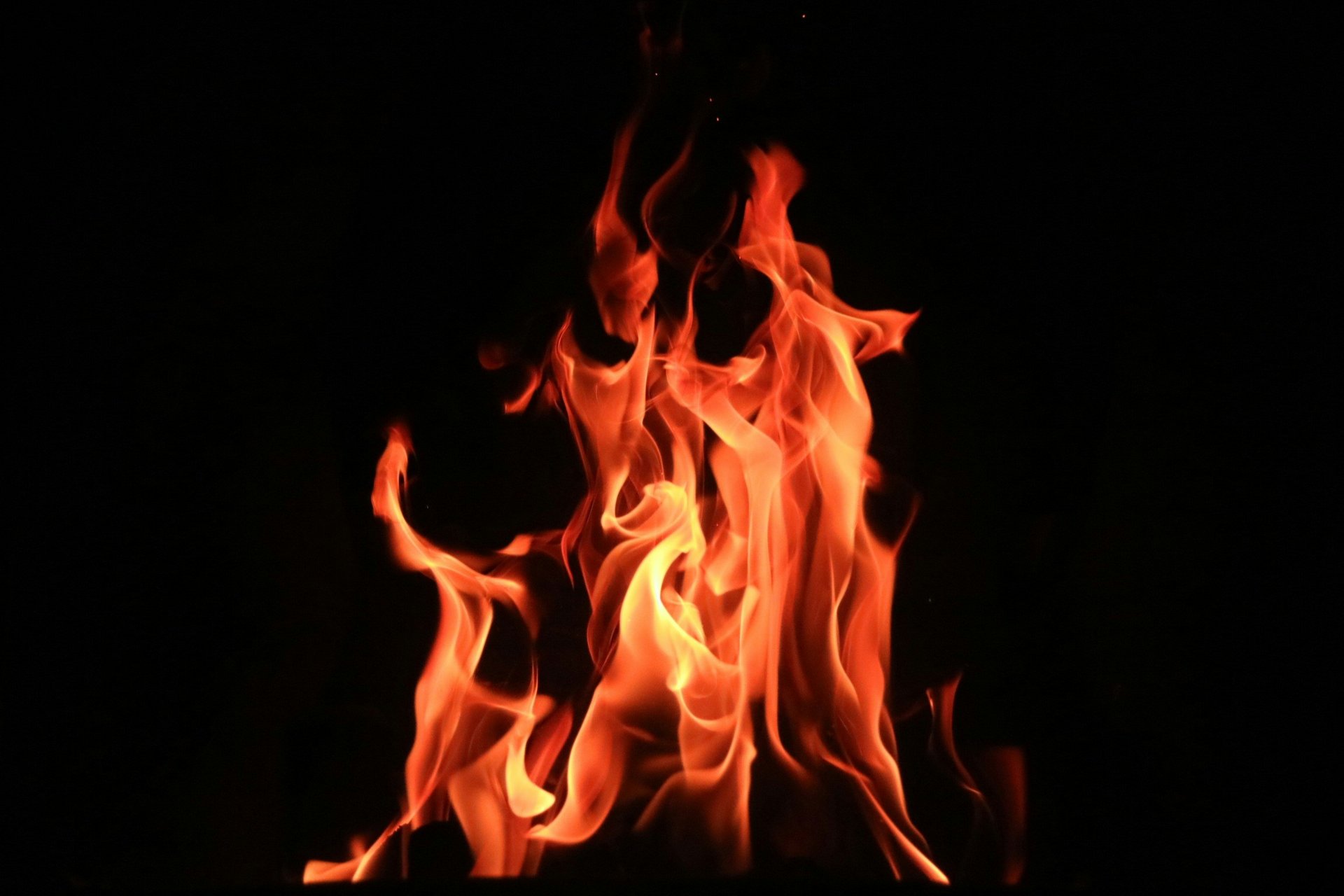 Flames dance in front of a black background