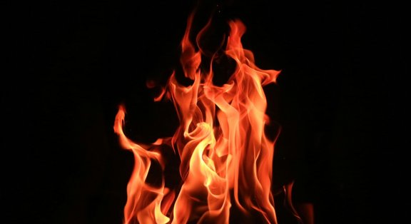 Flames dance in front of a black background