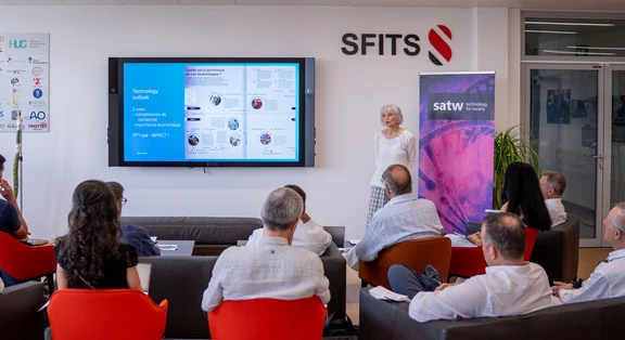 A presentation in a modern conference room with participants and a speaker
