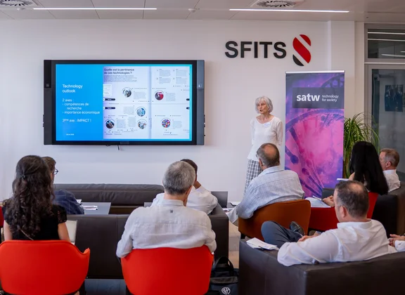 A presentation in a modern conference room with participants and a speaker