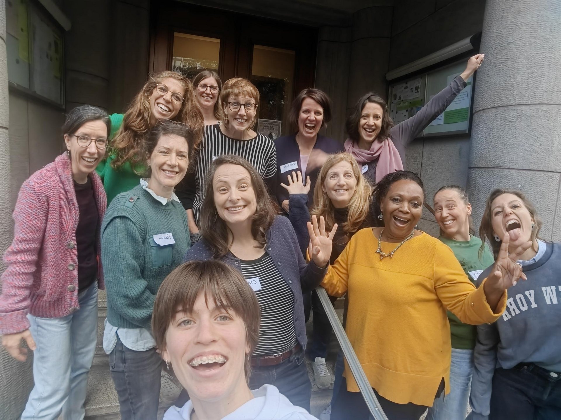 Group of cheerful women posing in front of a building