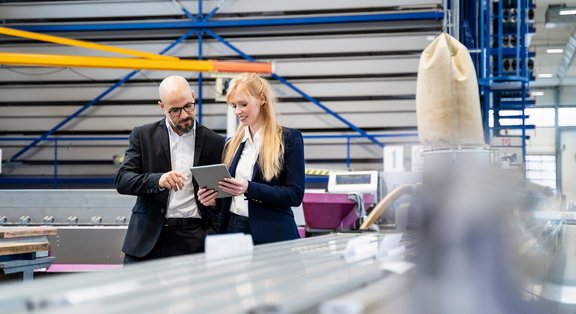 Colleagues reviewing data on a tablet in an industrial environment