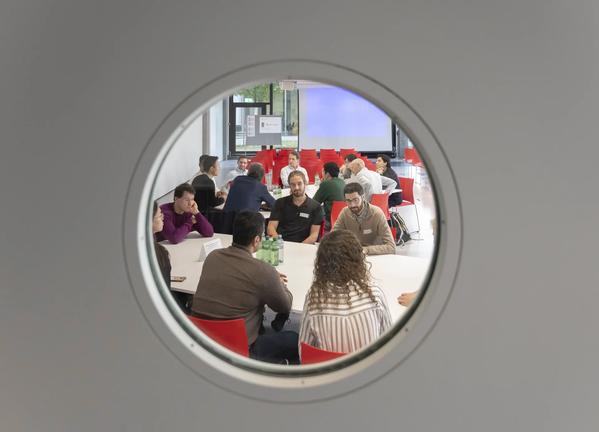 People in meeting seen through porthole
