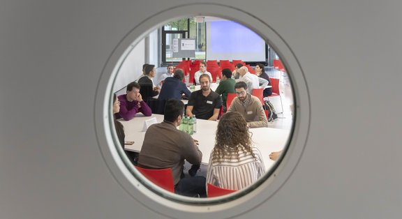 Des personnes en réunion vues à travers un hublot