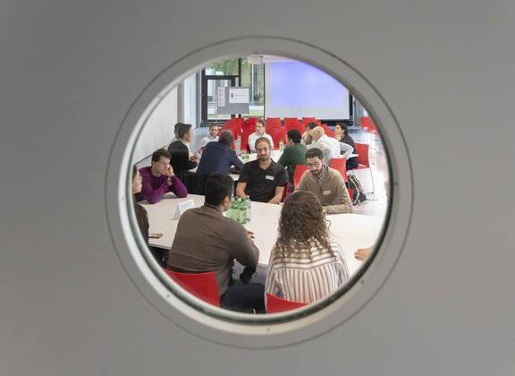 Des personnes en réunion vues à travers un hublot